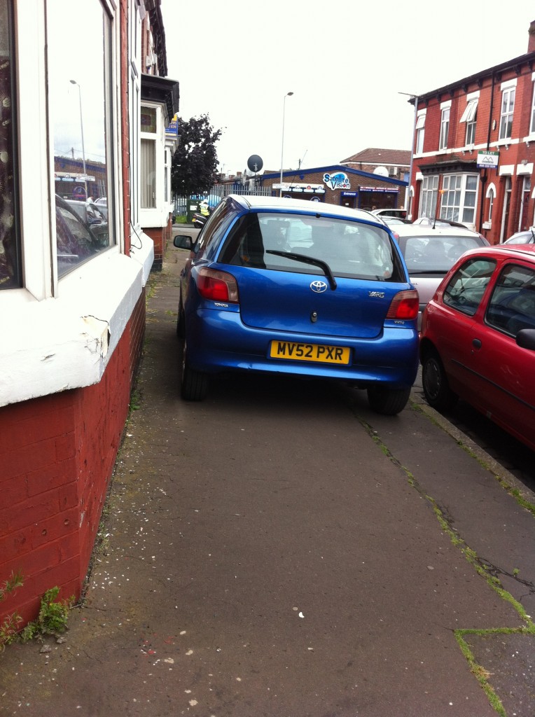 Car driving up the pavement on a residential street